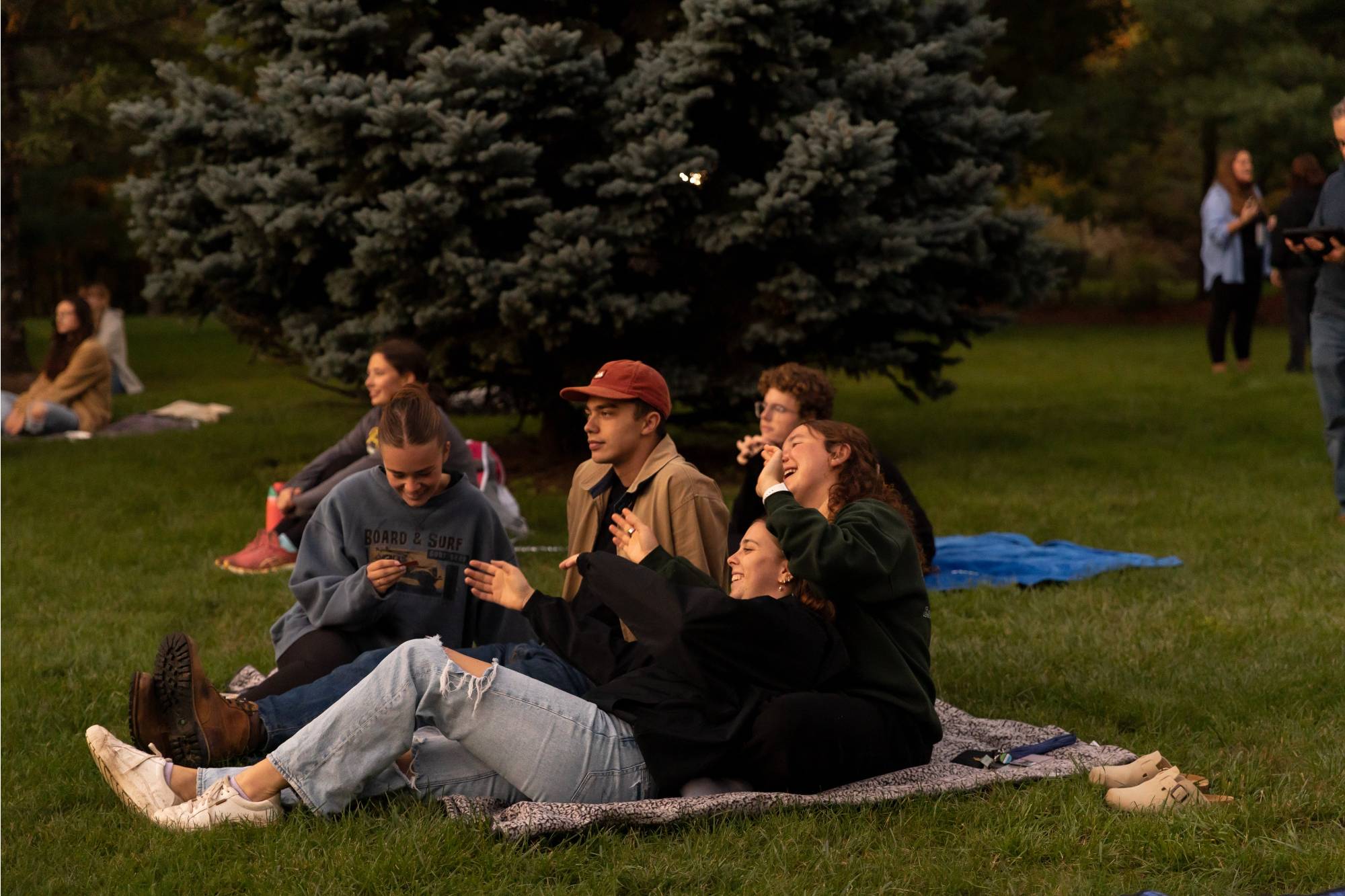 Students smiling while sitting on blankets